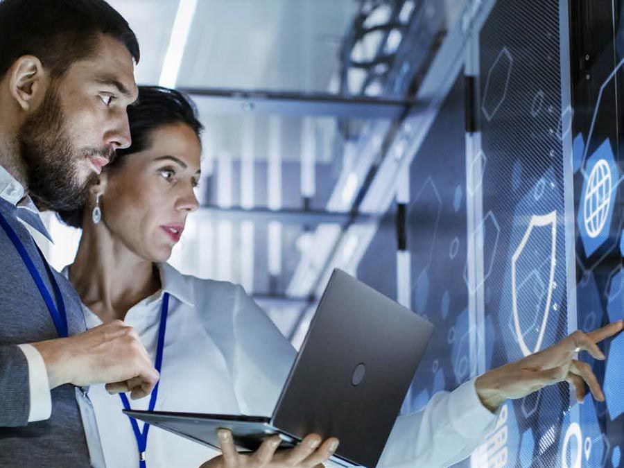 Two people looking at info on a large touchscreen