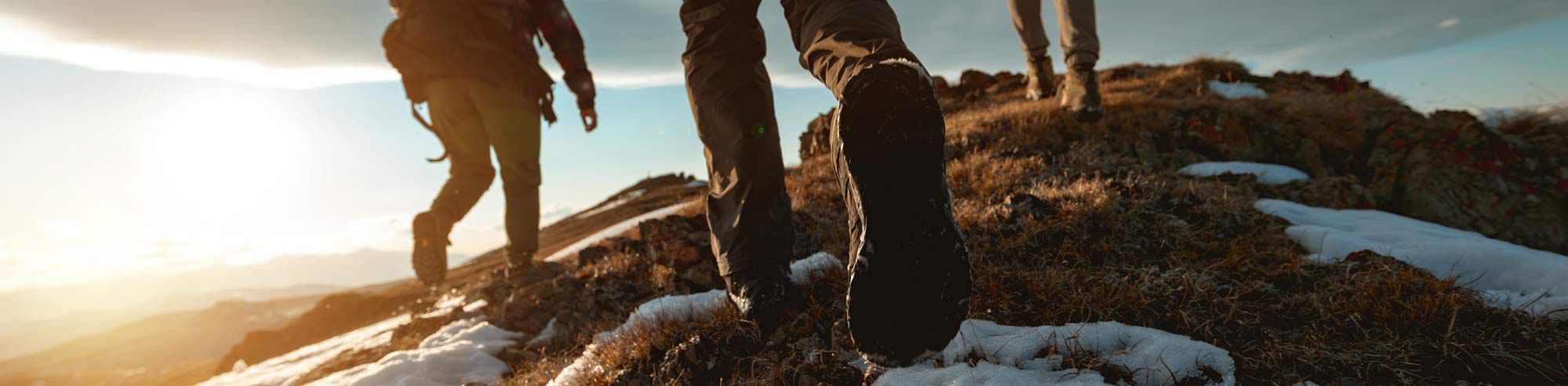 3 people walking up a hill