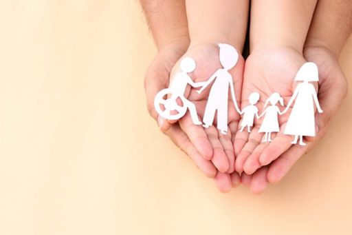 Hands holding paper cut-outs of a family