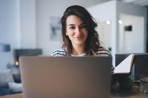 Half length portrait of cheerful woman student checking news and mail 