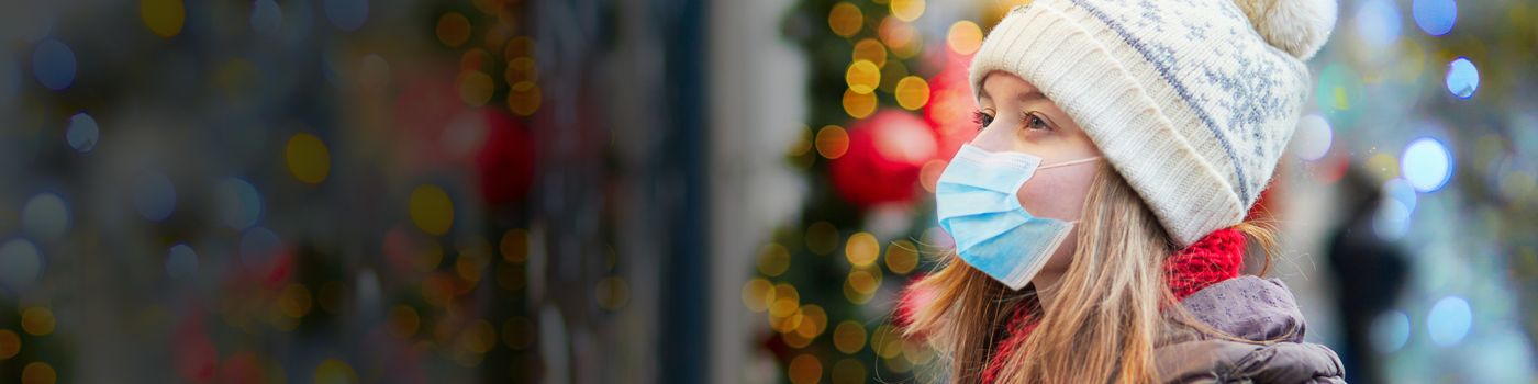 Woman wearing mask looking at Christmas shop windows