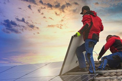 Two engineers working on solar panels on a roof