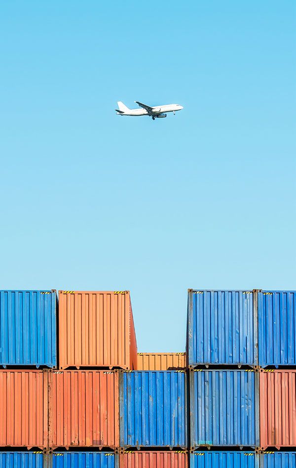 Plane flying over shipping containers