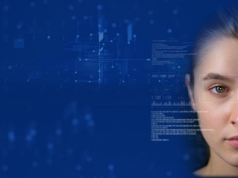 Woman's face with blueprints and code overlaid, blue background