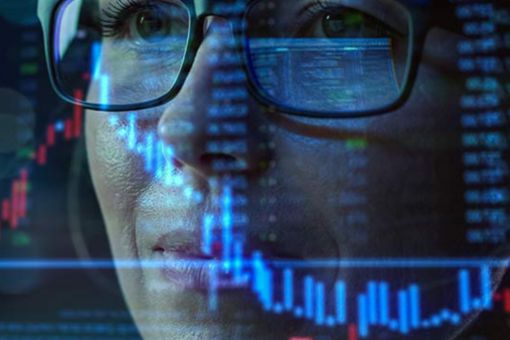 Woman's face reflected in computer screen showing a graph