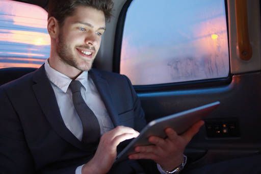 man in car holding tablet