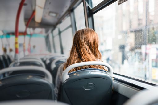 バスの車内から外を眺める女性