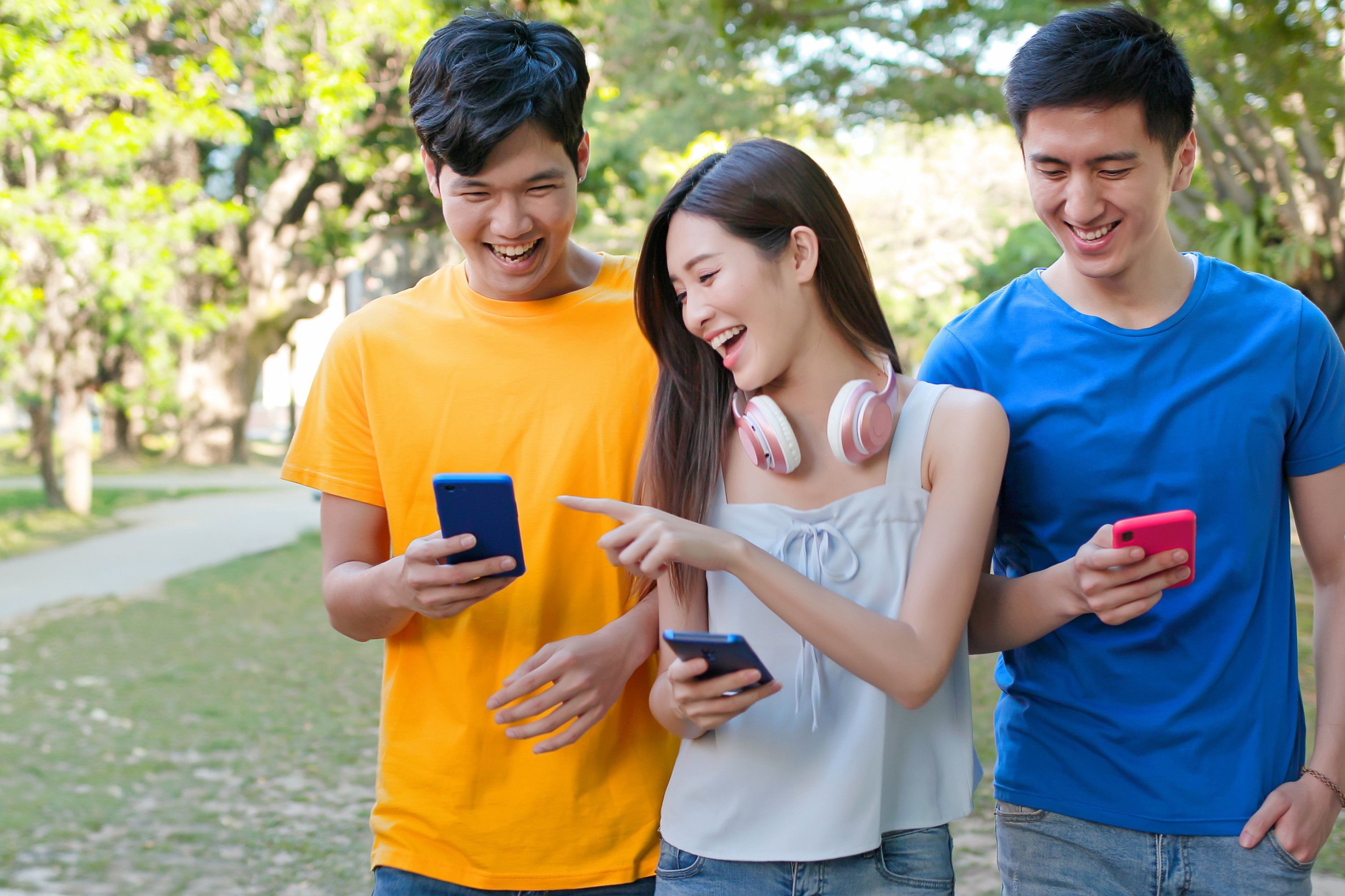 :スマートフォンを見ている 3人の男女