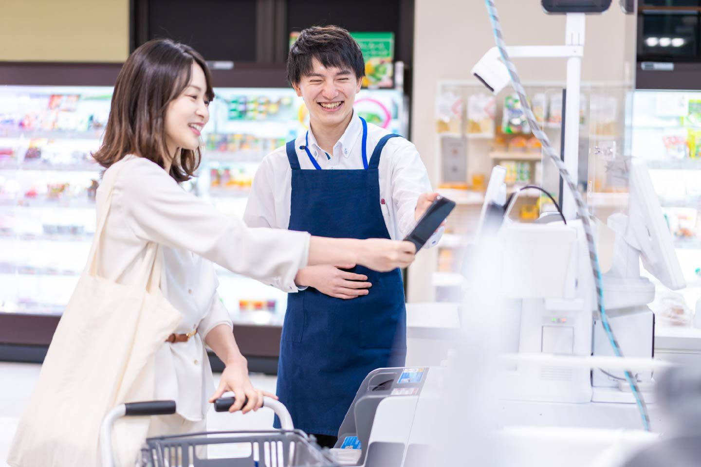  電子決済をする女性と案内する男性