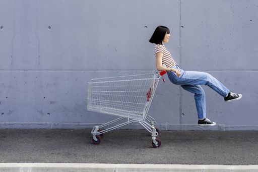 ショッピングカートに乗る女性
