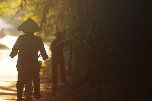 ベトナムの道を自転車で走行する人
