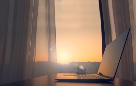 Laptop in front of blowing curtains