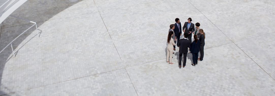 Business people standing in circle of modern courtyard