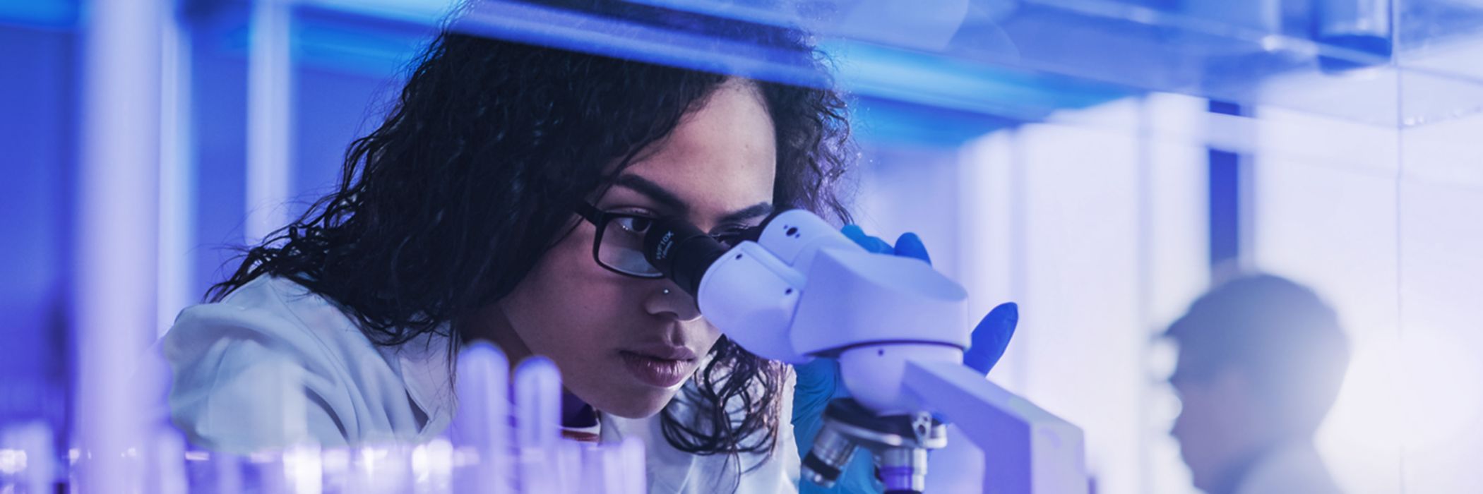Woman using microscope in lab - Life sciences