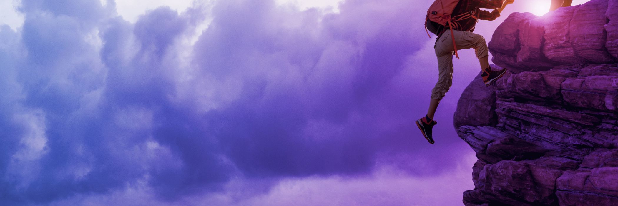 male hikers climbing rock