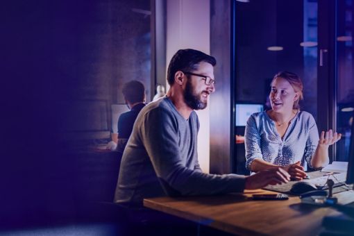 Man and woman looking at computer monitor in office