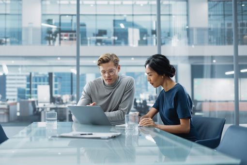 Business people looking at laptop