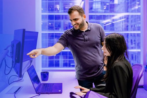 Man guiding a woman on desktop