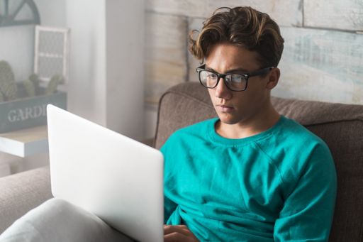 Man in specs using his laptop