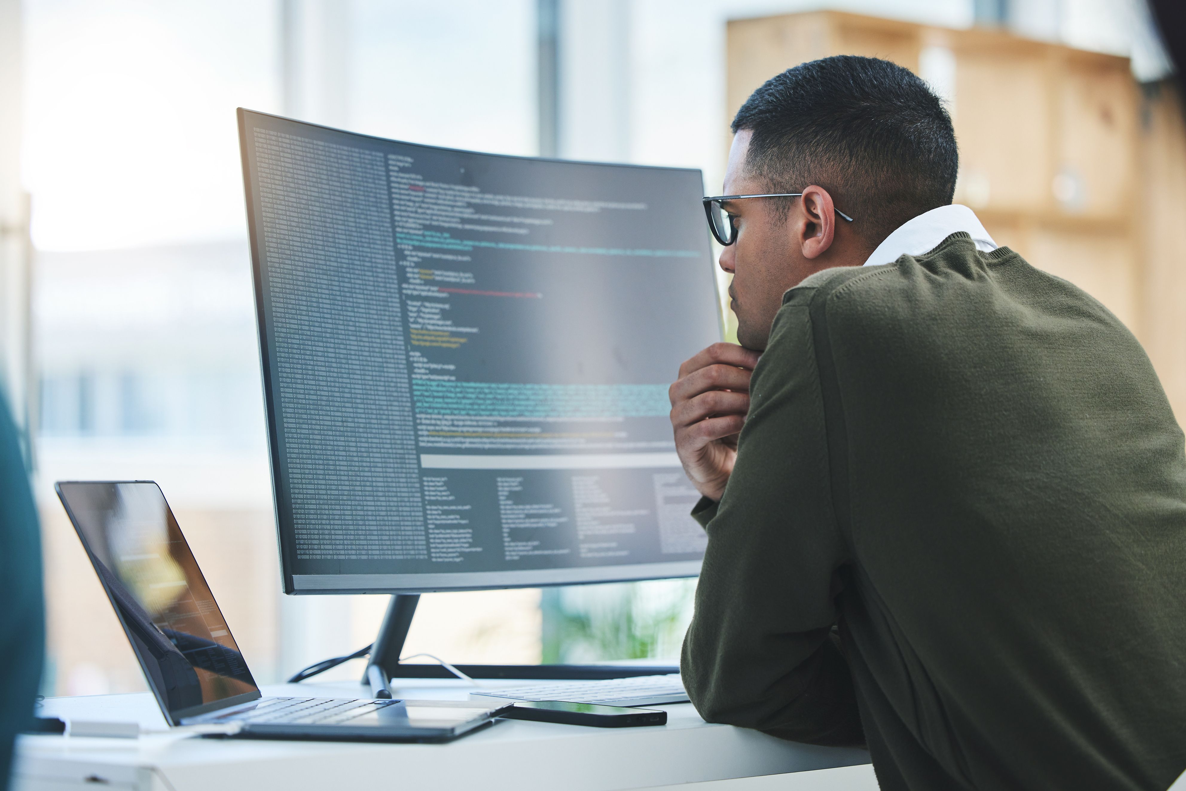 Man in spectacles looking at code