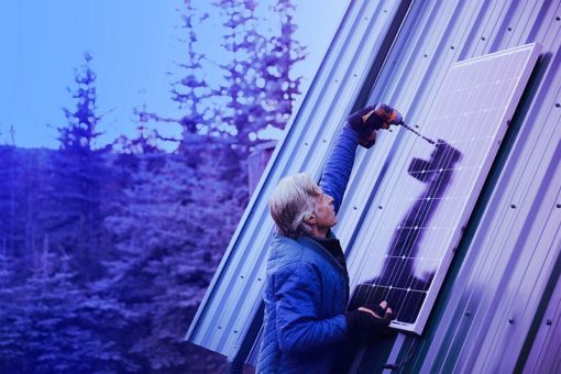 Man installing solar panel on roof