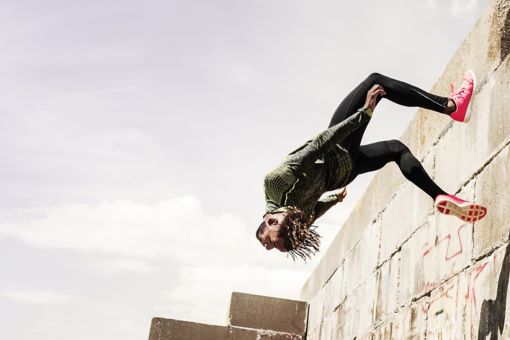 Man jumping backwards off a wall