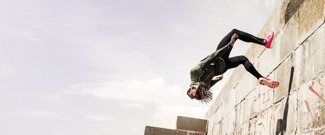 Man jumping backwards off a wall