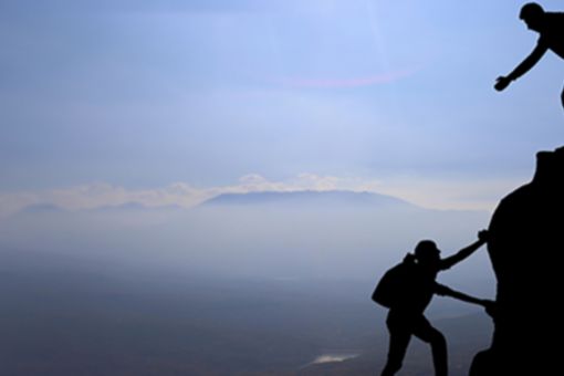 Man lending helping hand to woman hiker