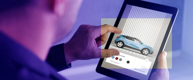 Man looking at car design on tablet