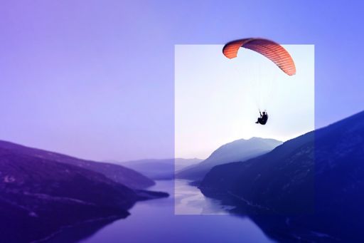Man on parachute over mountains