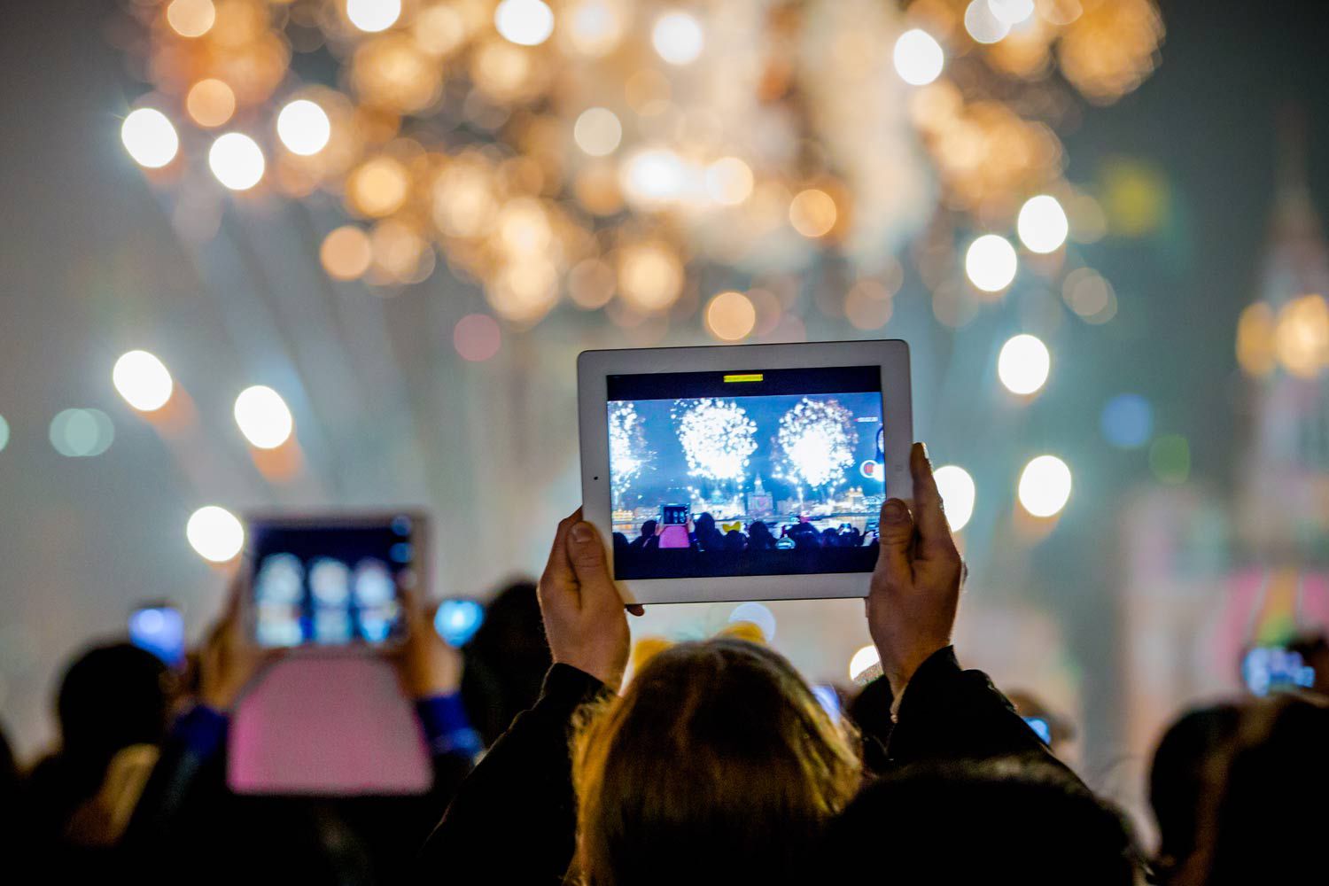 man recording a concert on his tablet