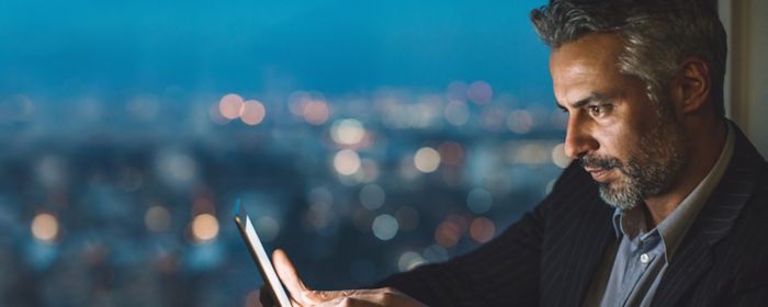 Man sitting at window using tablet