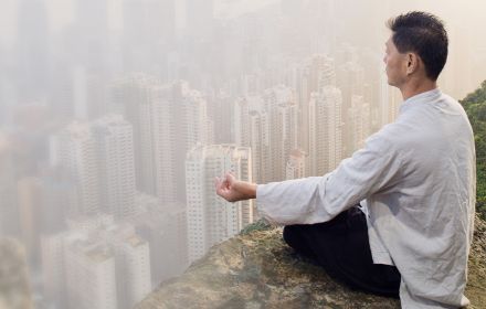 Man sitting on cliff yoga meditating