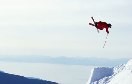 Mann springt mit Skiern von einer Klippe ab