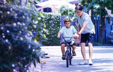 Man teaching son to ride bicycle