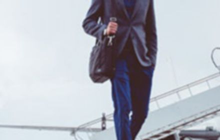 man-walking-on-runway-with-private-jet-in-background-banner