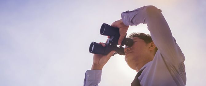 Man watching something through binoculars