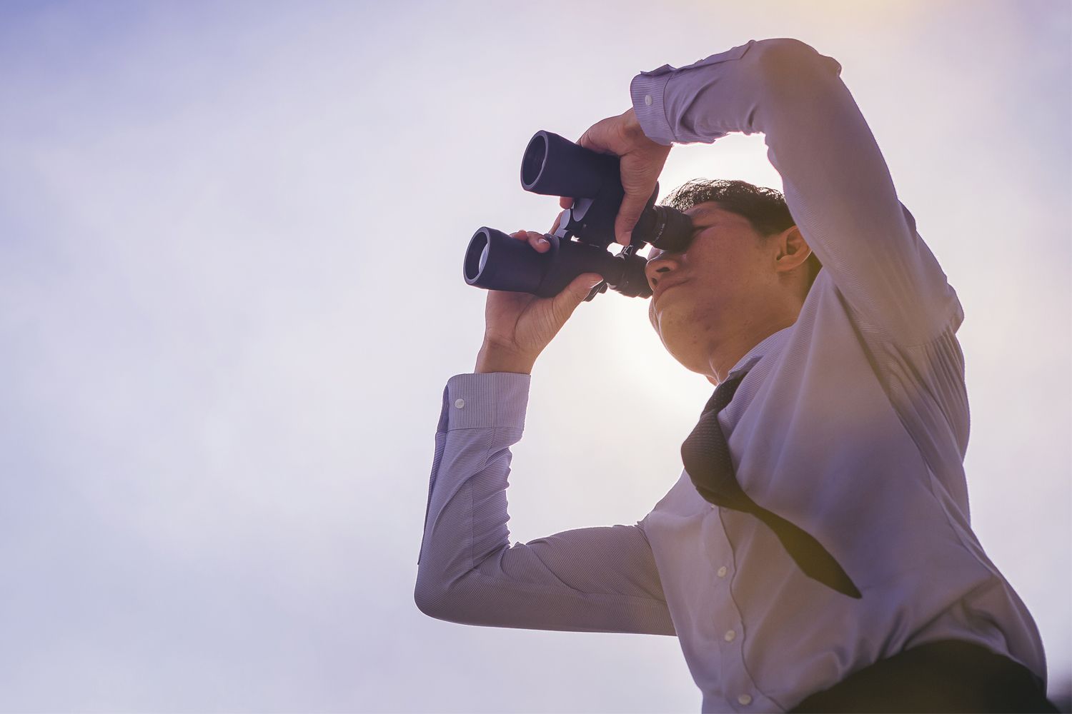 man watching through binoculars