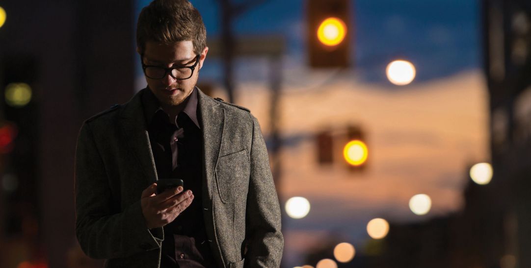 man wearing glasses using mobile