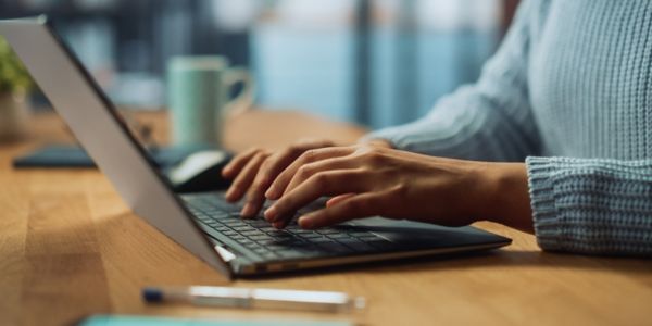 hands typing on laptop