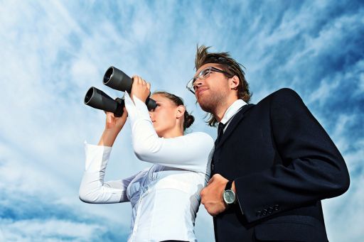 man and woman looking through binoculars