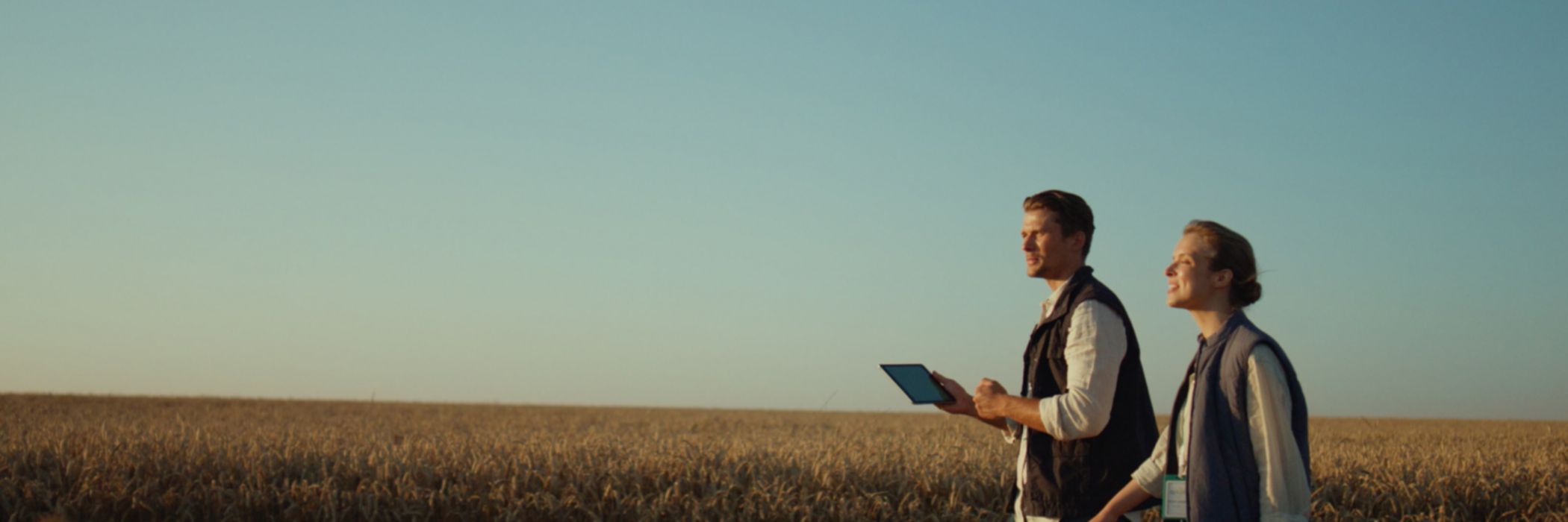 man woman with tablet in fields