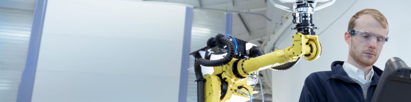 Man working in laboratory with robot arm and machines