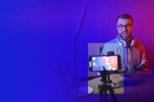 Mann vor Handy im Stativ