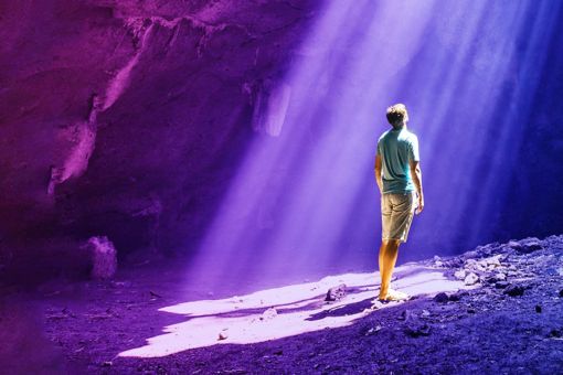 Mann in Höhle schaut ins Licht