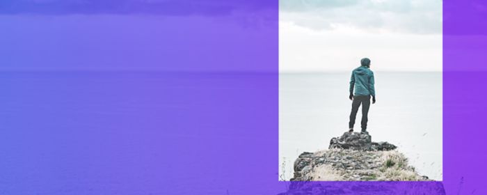 Man standing on stones by the sea