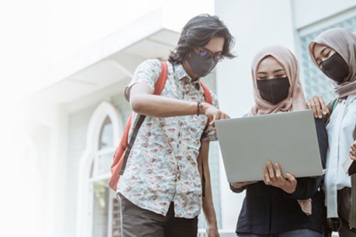 masked individuals with a laptop