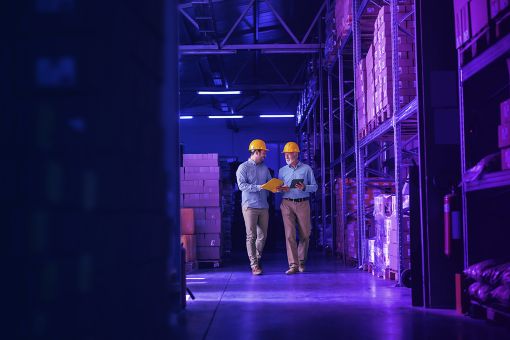 men walking in warehouse wearing yellow safety helmets