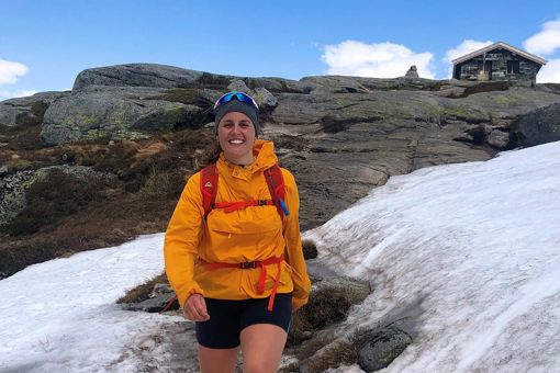 Nora Sande går i over et snødekt fjell