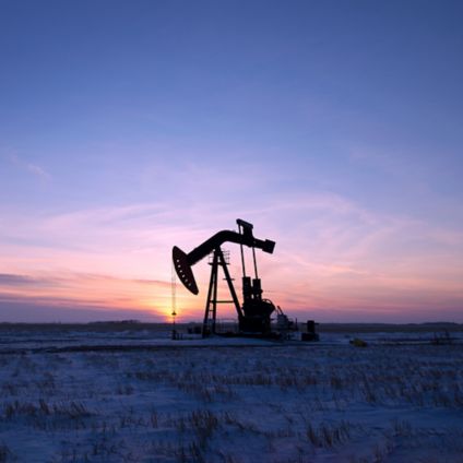 An oil drilling rig and pumpjack on a flat plain